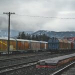 train running on train track under gray sky at daytime