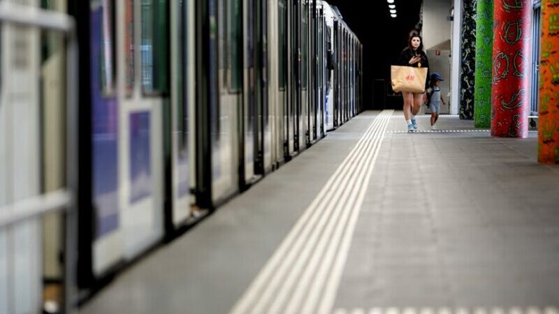 woman with a small child hurries across the station platform to catch the train